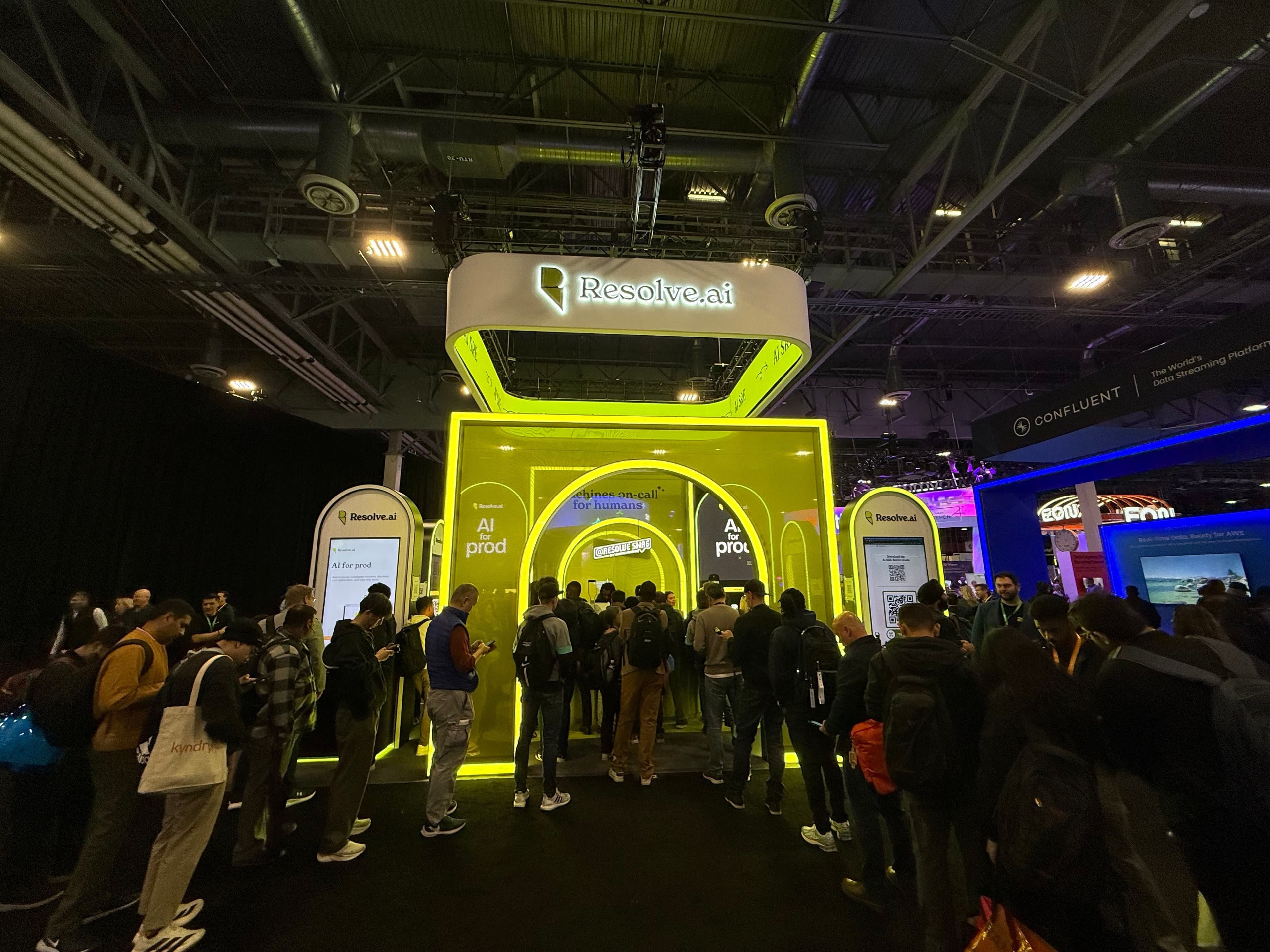 Resolve.ai booth at AWS re:Invent 2025 with a crowd gathered in front of the glowing yellow arches